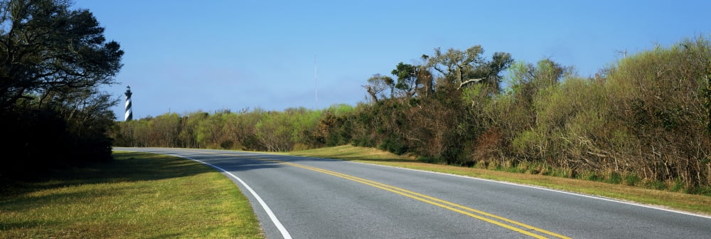 Road leading towards a lighthouse Cape Hatteras Lighthouse Outer Banks North Carolina USA Canvas Art - Panoramic Images (36 x 12)