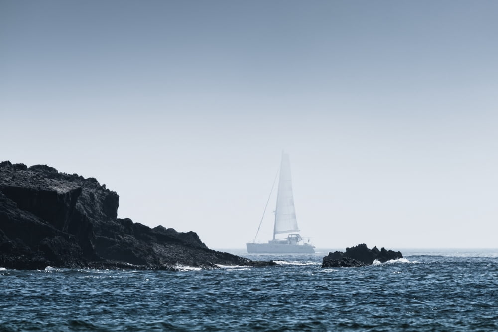 Rock on the rugged coastline with a sailboat in the fog Tarifa Cadiz Andalusia Spain Canvas Art - Ben Welsh Design Pics (19 x 12)