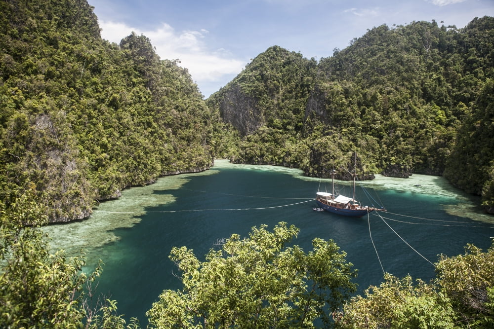 Rugged limestone islands frame an Indonesian pinisi schooner Canvas Art - Ethan DanielsStocktrek Images (17 x 12)