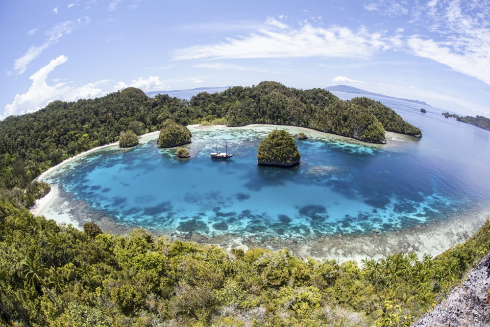 Rugged limestone islands surround a lagoon in Raja Ampat Canvas Art - Ethan DanielsStocktrek Images (17 x 12)