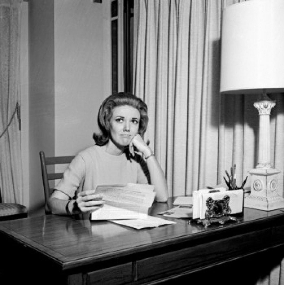 Sad young woman sitting at desk holding letter Canvas Art - (18 x 24)