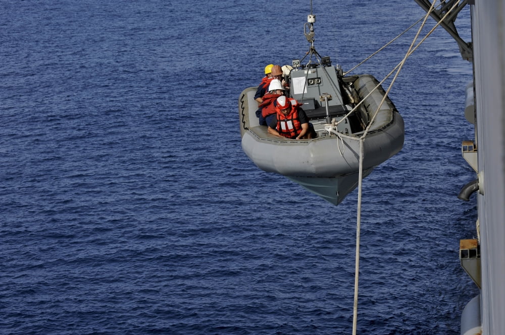 Sailors lower a rigid-hull inflatable boat Canvas Art - Stocktrek Images (35 x 23)