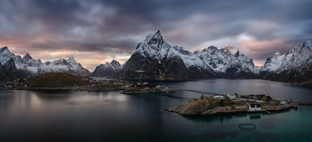 Sakrisoya village on Reinefjorden among snowy mountains at sunset Lofoten Nordland Norway Canvas Art - Panoramic Images (7 x 15)