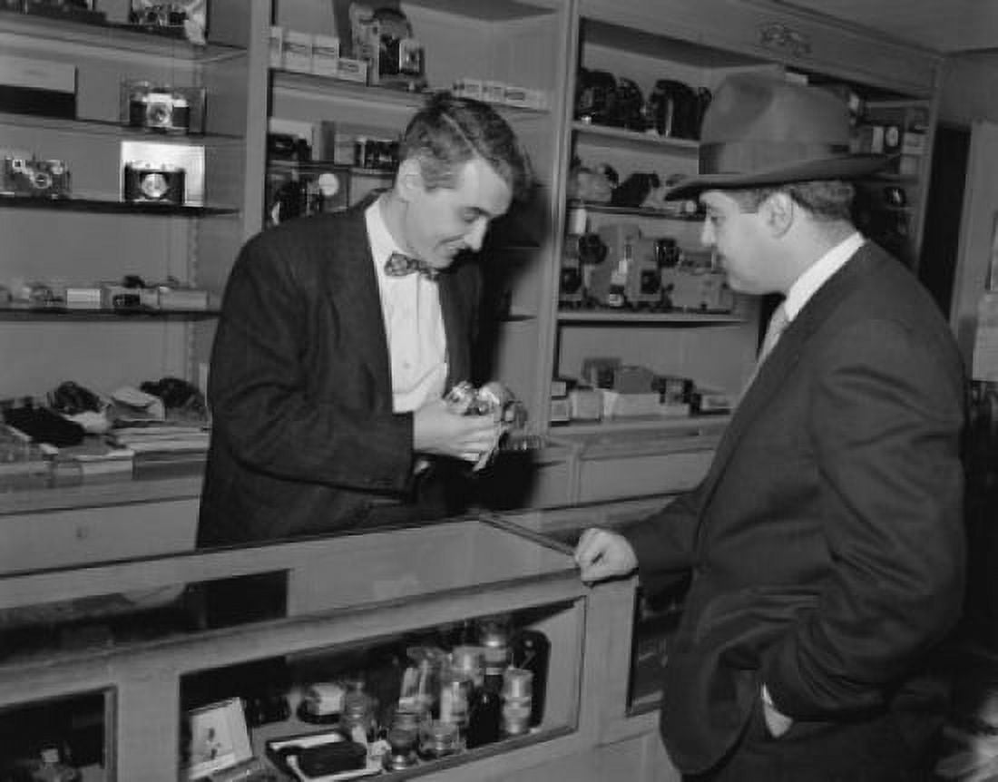 Salesman showing a camera to a customer in a store Canvas Art - (18 x 24)