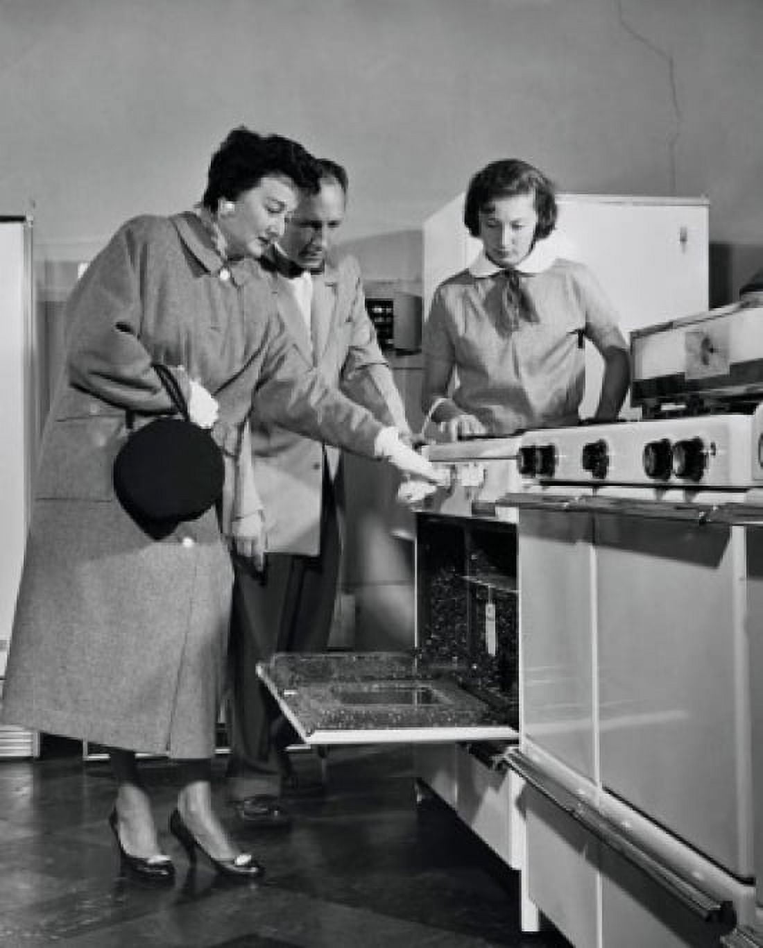 Salesman showing an oven to female customers in a store Canvas Art - (18 x 24)