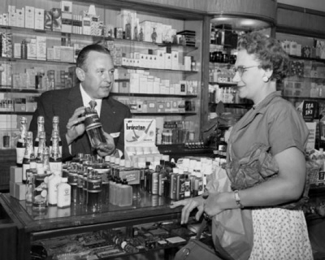 Salesman showing bottle to mid adult woman in store Canvas Art - (24 x 36)