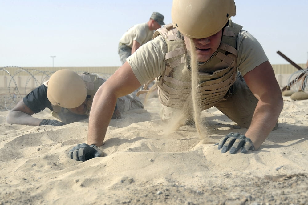 Sand falls from the helmet of a soldier as he gets up after crawling through a sandpit Canvas Art - Stocktrek Images (34 x 23)