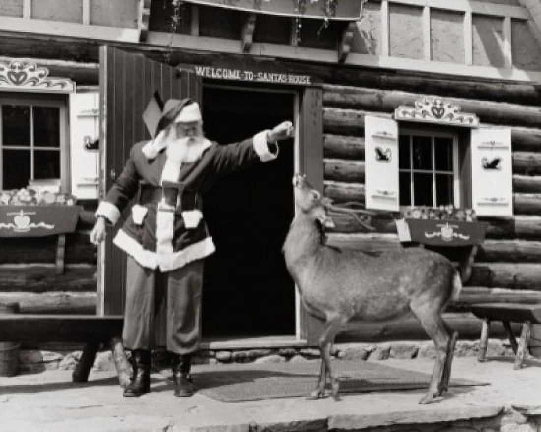 Santa Claus feeding a reindeer Canvas Art - (24 x 36)
