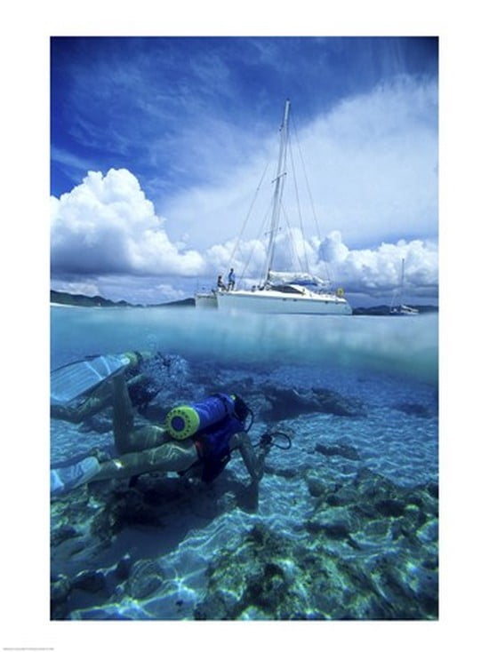 Scuba diver in the water with a sail boat in the background British Virgin Islands Canvas Art - (18 x 24)
