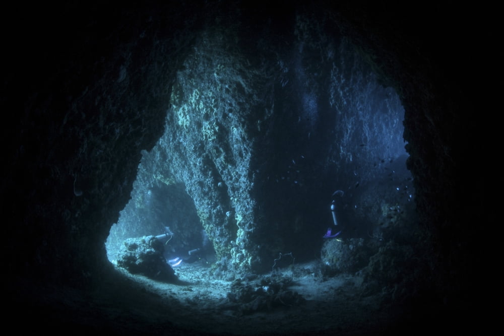 Scuba divers explore a cave near the island of Sulawesi Indonesia Canvas Art - Ethan DanielsStocktrek Images (17 x 12)