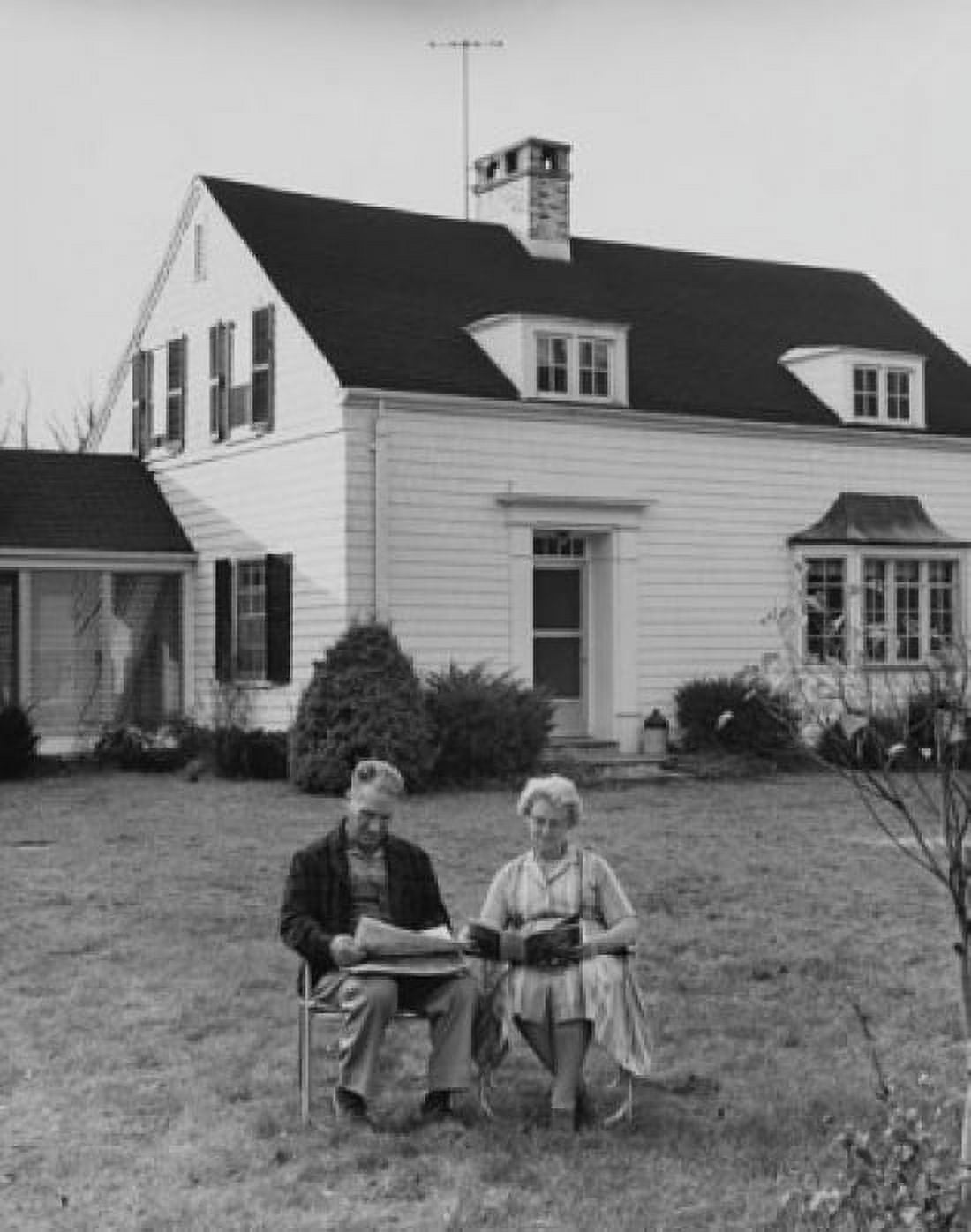 Senior couple reading newspaper in the front yard Canvas Art - (18 x 24)