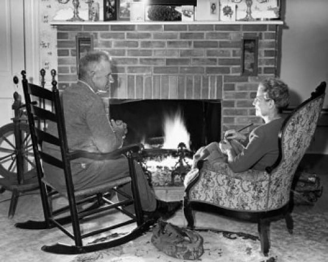 Senior couple sitting in front of a fireplace Canvas Art - (18 x 24)