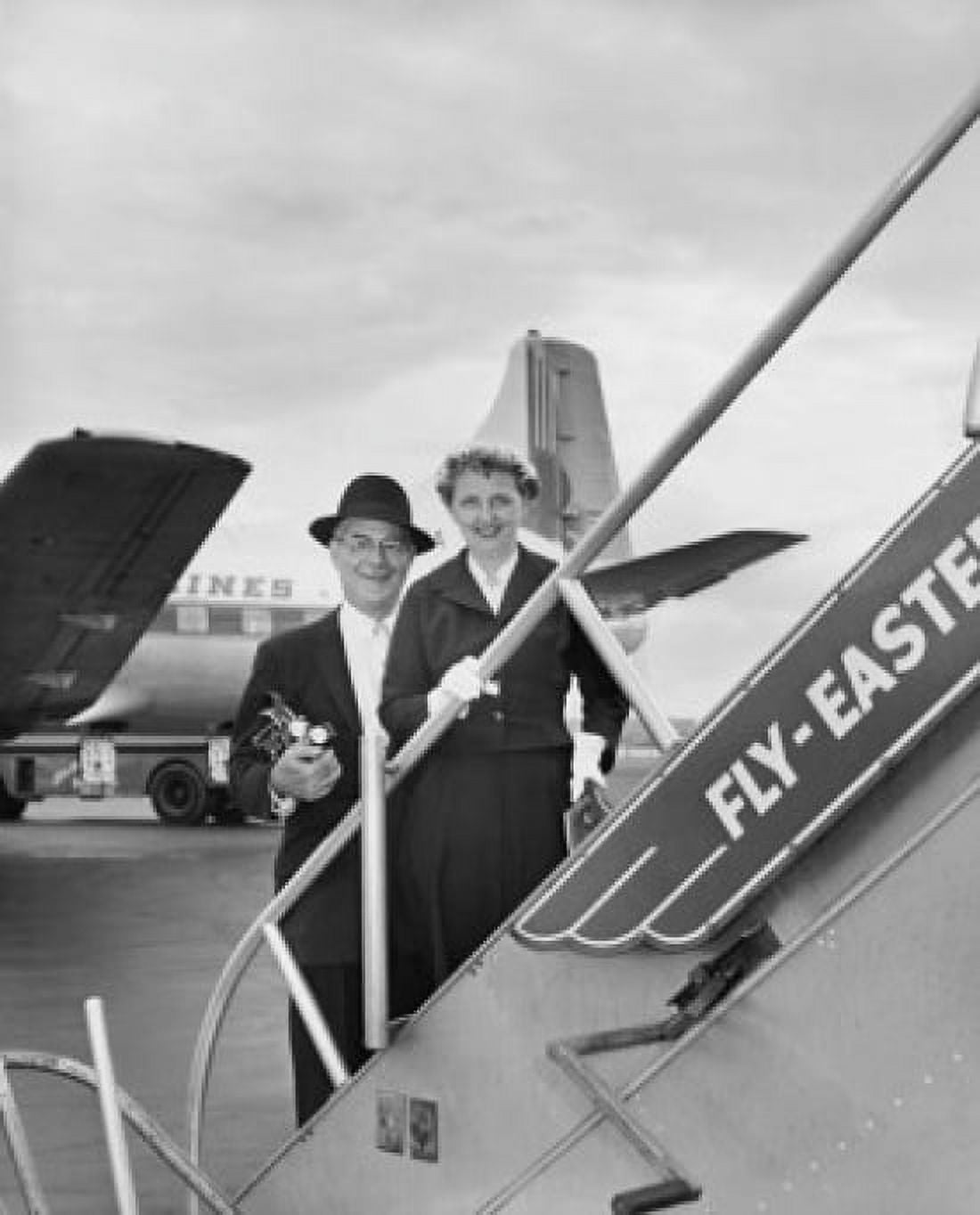 Senior couple standing on the staircase of an airplane Canvas Art - (24 x 36)