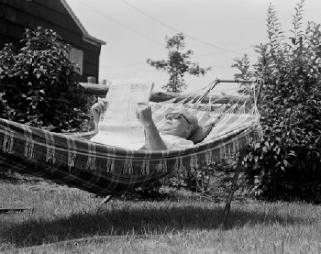 Senior man reading newspaper in hammock Canvas Art - (24 x 36)