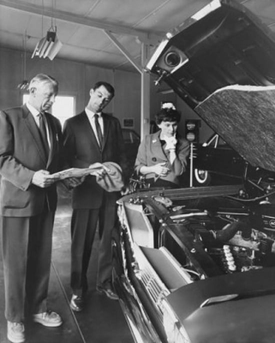Senior man showing a car to a mid adult couple in a showroom Canvas Art - (24 x 36)