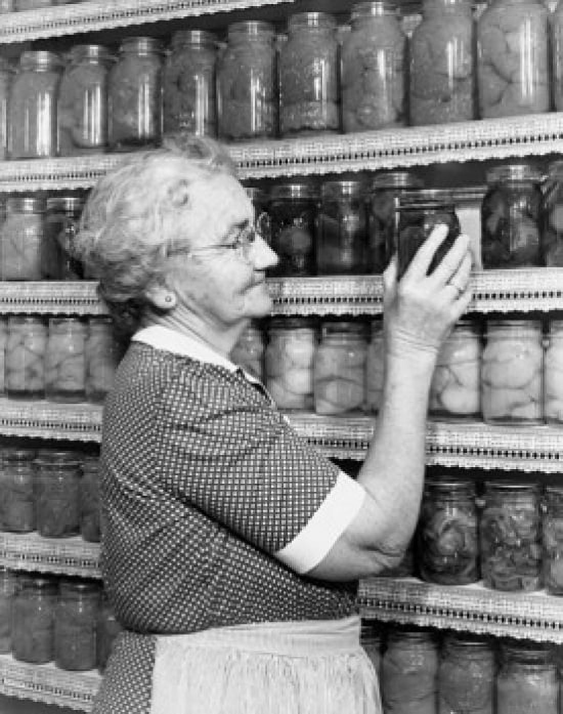 Senior woman choosing a jar of pickled vegetables Canvas Art - (24 x 36)