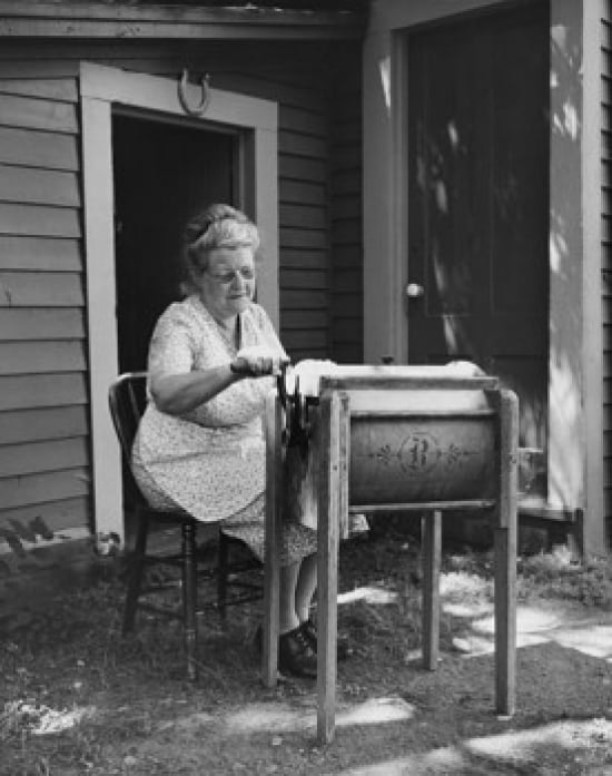 Senior woman churning butter in a butter churn Canvas Art - (18 x 24)