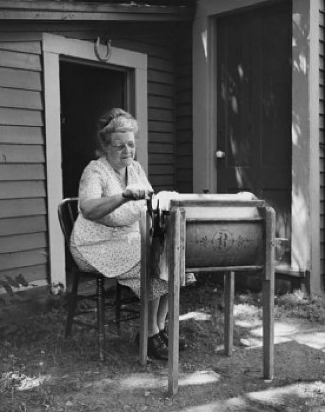 Senior woman churning butter in a butter churn Canvas Art - (24 x 36)
