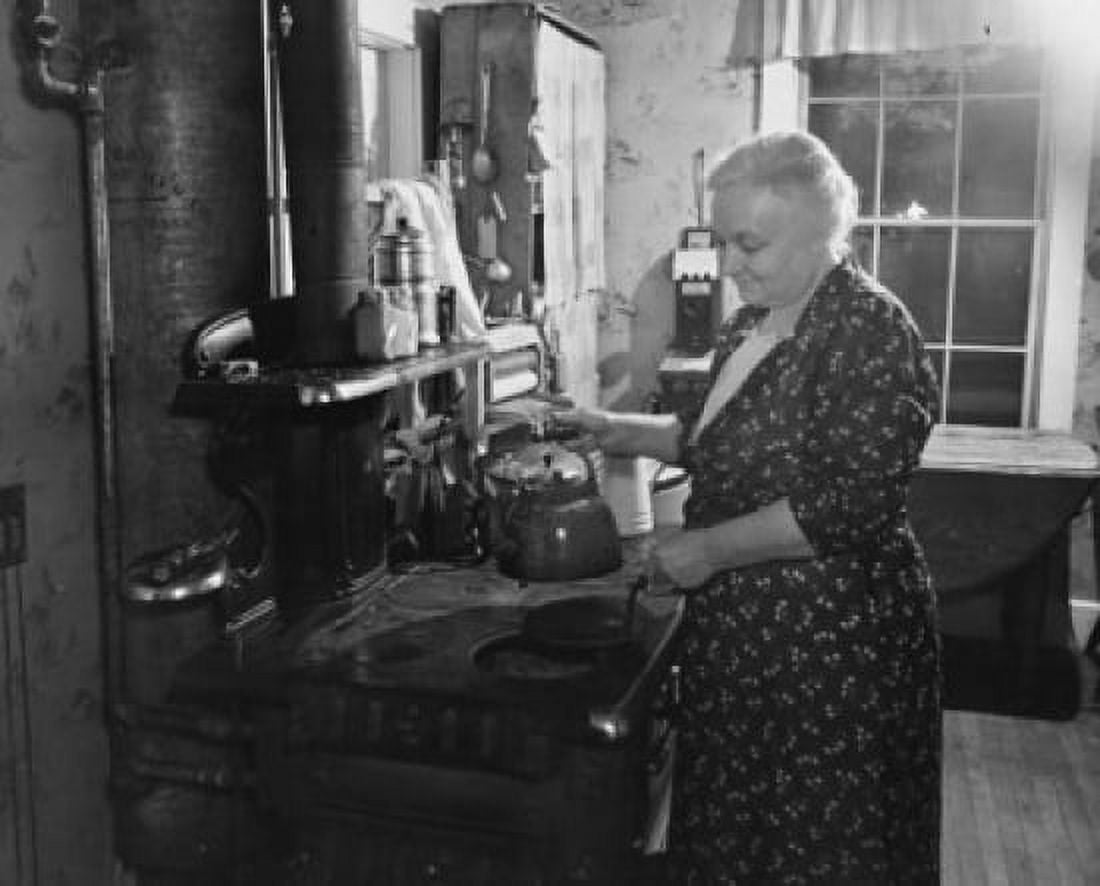 Senior woman holding a tea kettle in the kitchen Canvas Art - (18 x 24)