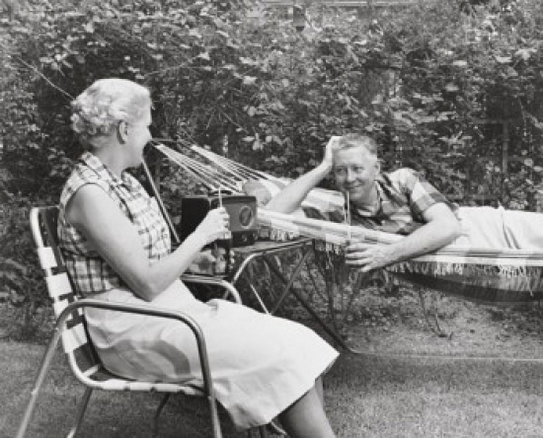 Senior woman sitting in a chair and a senior man lying in a hammock beside her Canvas Art - (24 x 36)