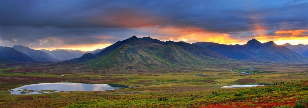 Shafts Of Sunlight Rising Above The Mountains And Fall Colours Of The Dempster Highway Yukon Canvas Art - First Light Design Pics (23 x 8)