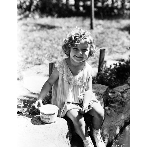 Shirley Temple sitting on the River Bank in aClassic Portrait Photo Print (8 x 10)