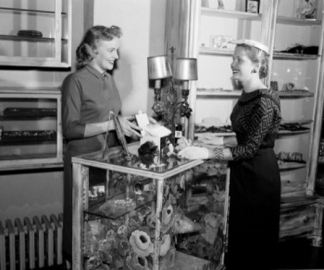 Shop assistant showing goods to customer in shop Canvas Art - (24 x 36)