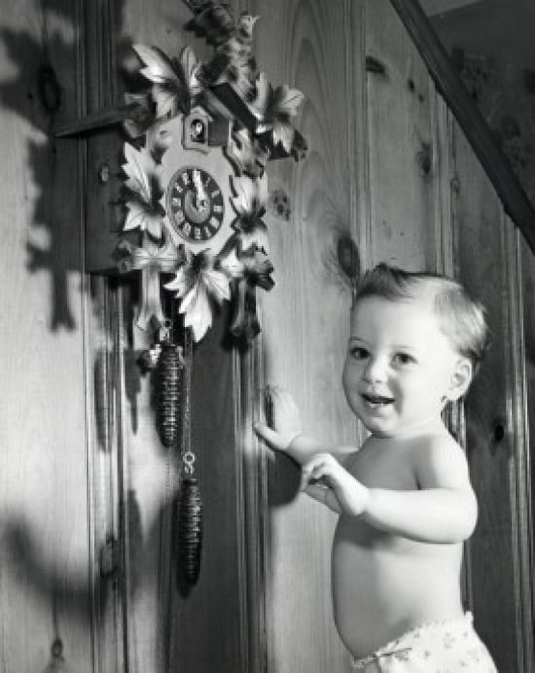 Side profile of a baby boy standing near a cuckoo clock and smiling Canvas Art - (18 x 24)