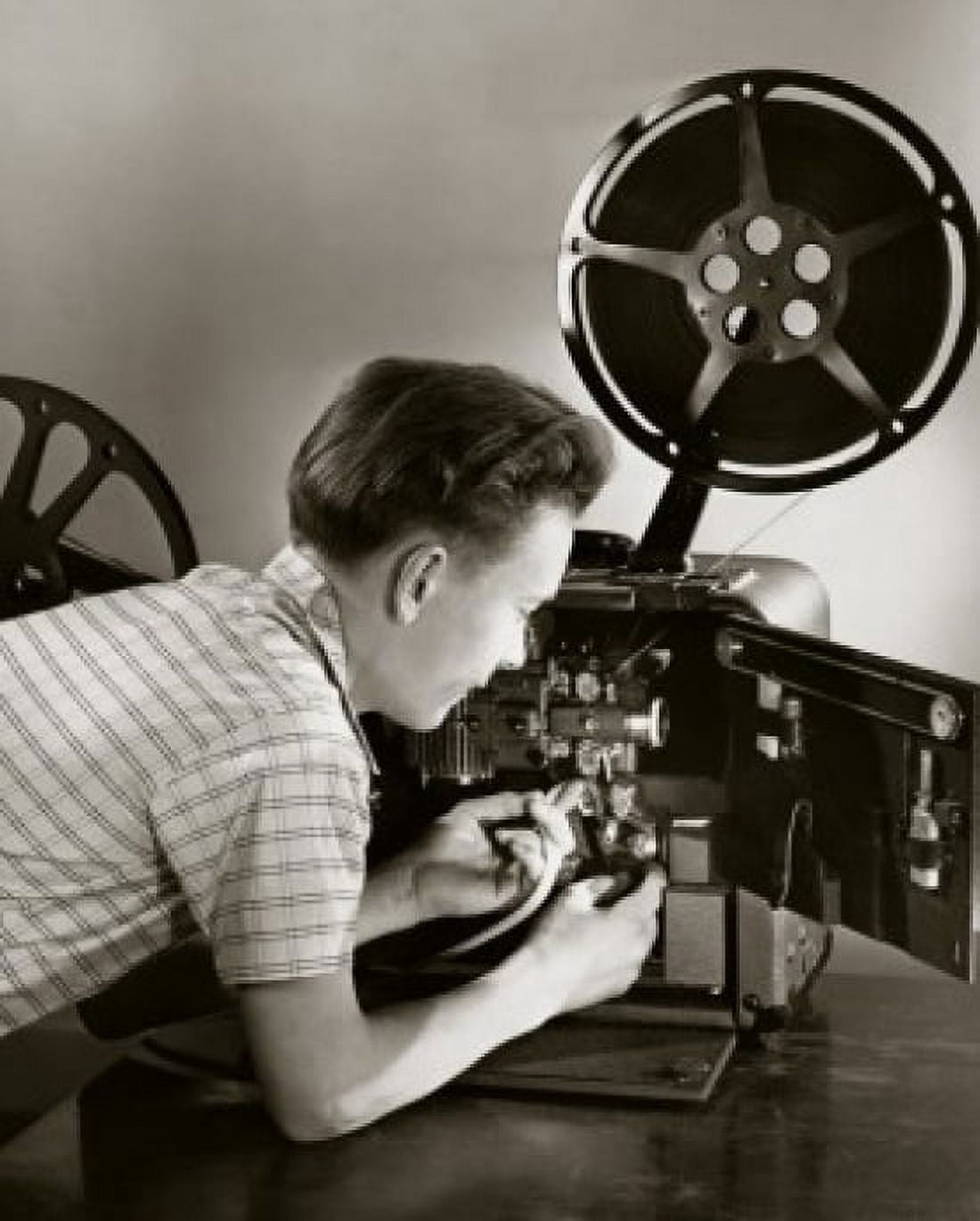 Side profile of a boy loading a film reel on a projector Canvas Art - (18 x 24)
