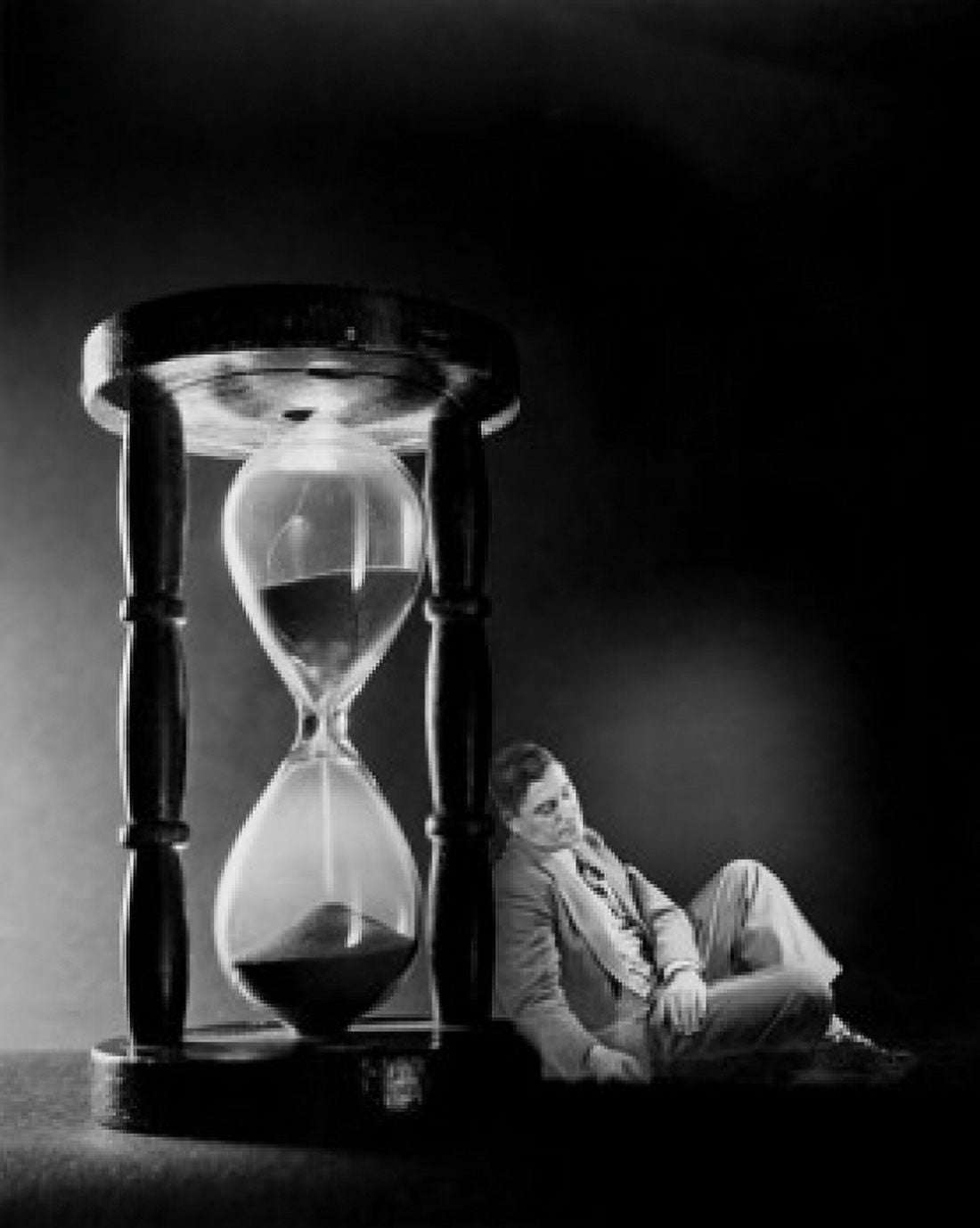 Side profile of a businessman leaning against an hourglass Canvas Art - (18 x 24)