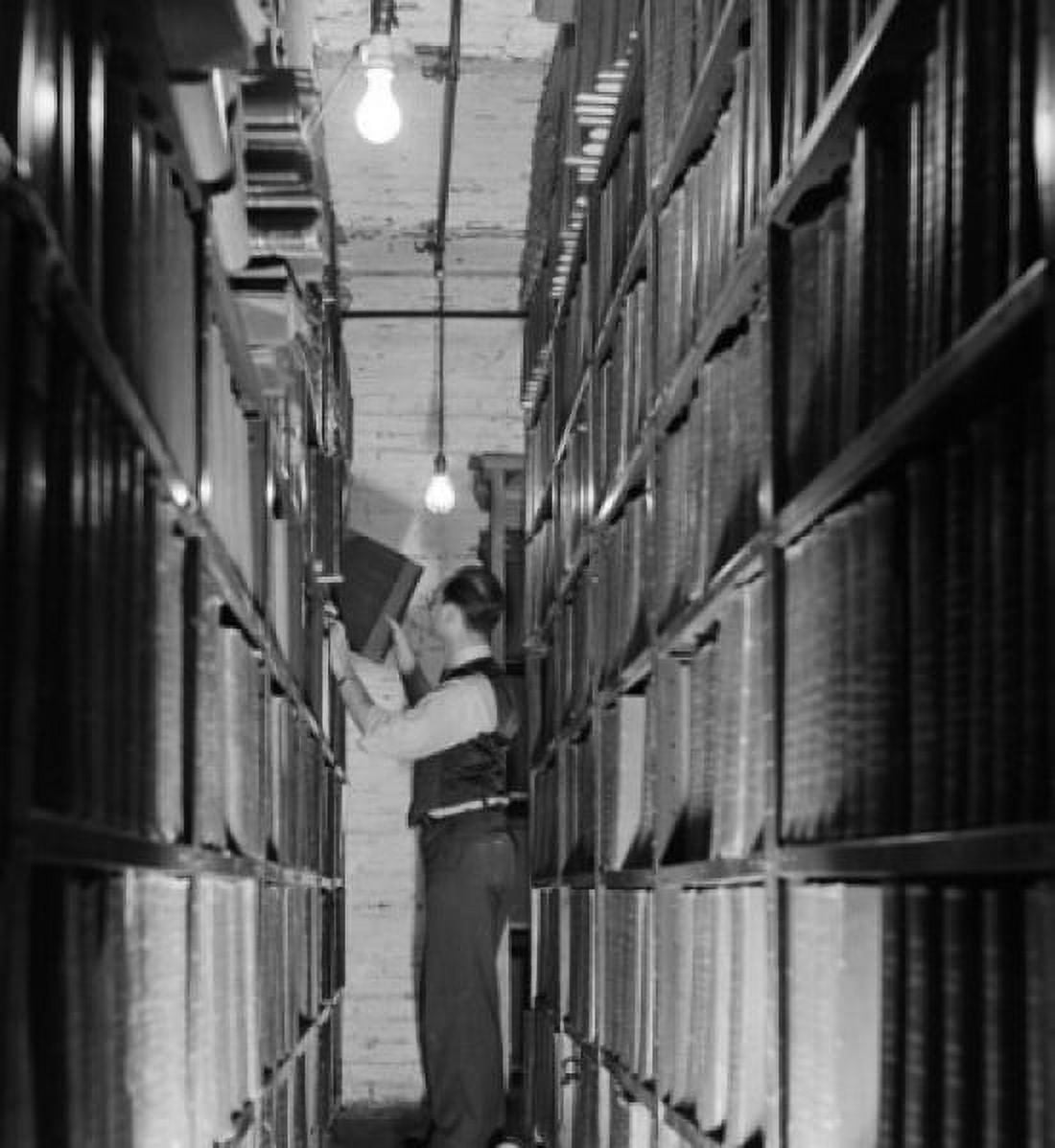 Side profile of a businessman pulling a file from a shelf Canvas Art - (24 x 36)