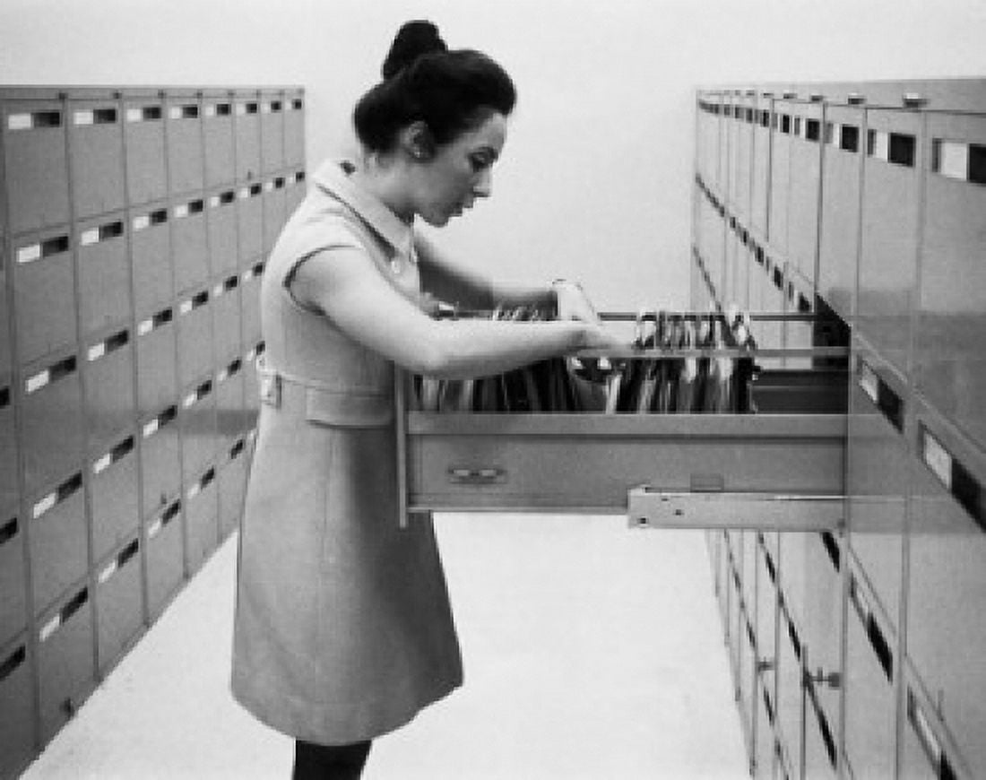 Side profile of a businesswoman searching for files in a filing cabinet Canvas Art - (24 x 36)