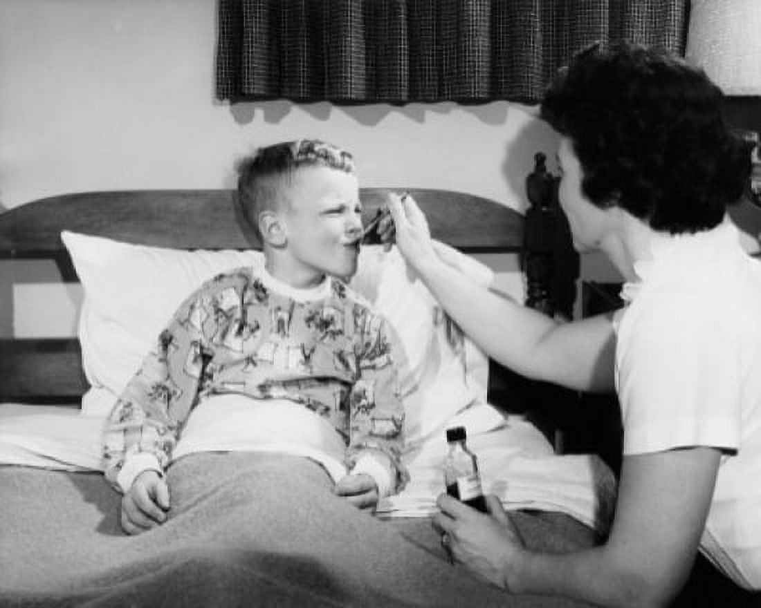 Side profile of a female pediatrician giving medicine to a boy Canvas Art - (24 x 36)