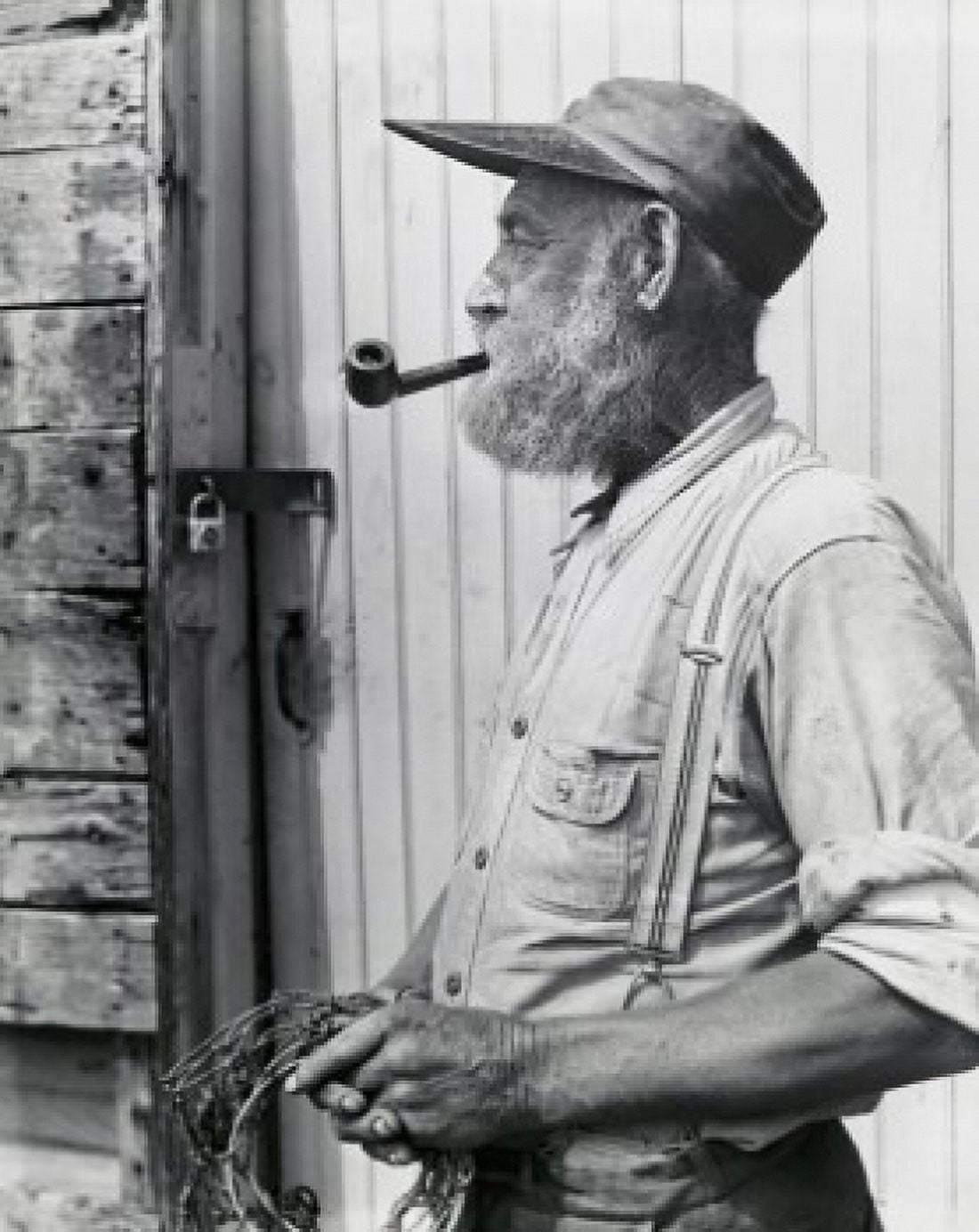 Side profile of a fisherman holding a fishing net and smoking a pipe Canvas Art - (24 x 36)
