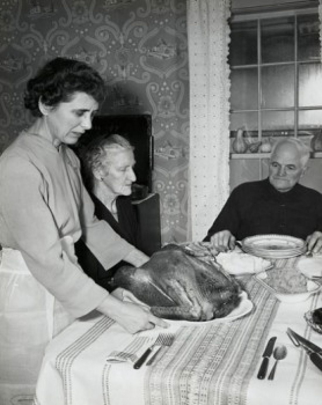 Side profile of a mature woman serving a roasted turkey to her parents on Thanksgiving Day Canvas Art - (18 x 24)