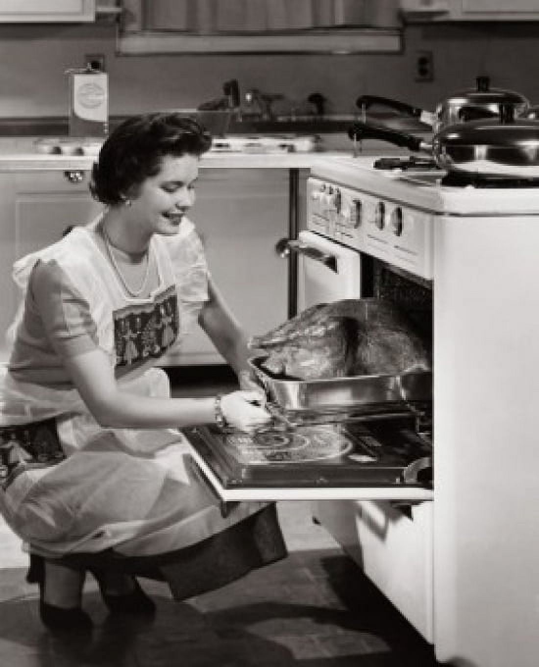 Side profile of a mid adult woman putting a turkey into an oven Canvas Art - (24 x 36)