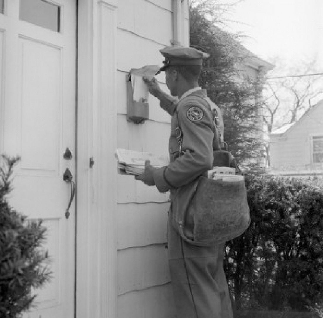 Side profile of a postman dropping mail in a mailbox Canvas Art - (18 x 24)