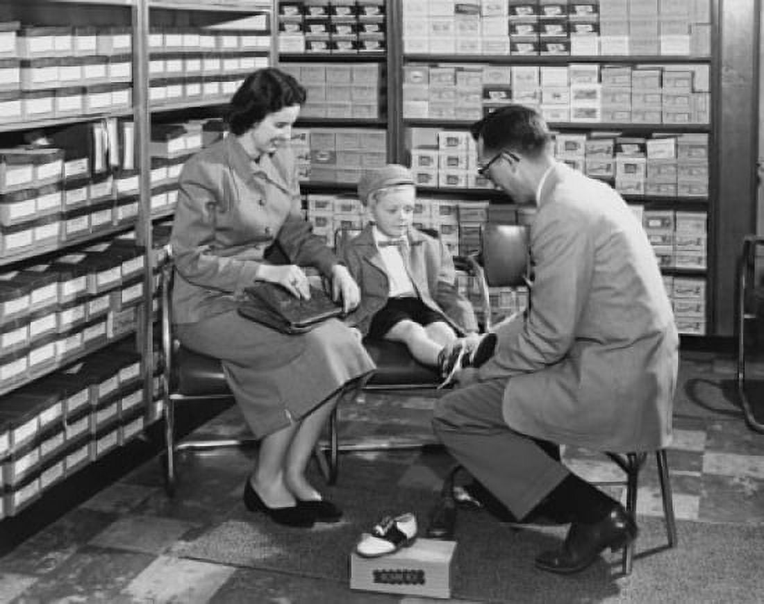 Side profile of a sales clerk helping a boy try on shoes in a shoe store Canvas Art - (18 x 24)