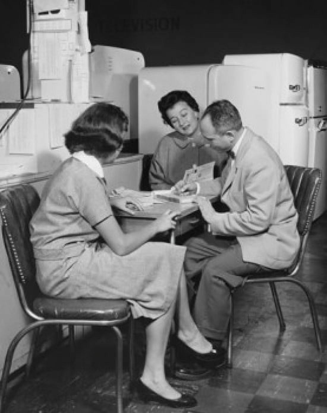 Side profile of a salesman sitting with two female customers in a store Canvas Art - (24 x 36)