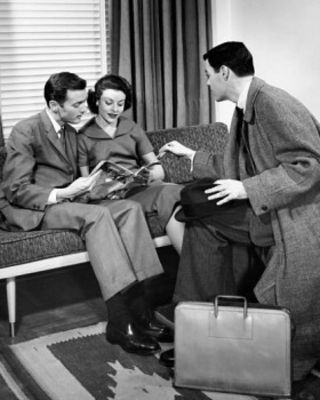 Side profile of a salesman talking to a young couple sitting on a couch Canvas Art - (18 x 24)