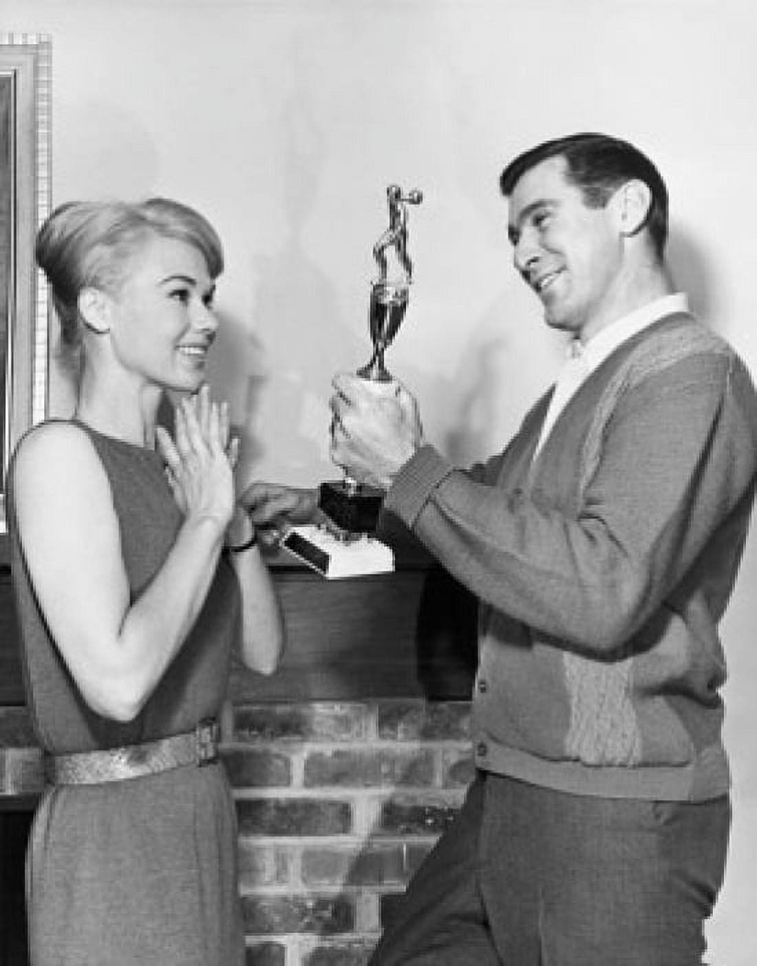 Side profile of a young man showing a trophy to a young woman Canvas Art - (18 x 24)