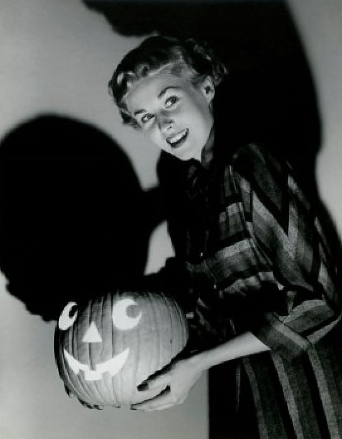 Side profile of a young woman holding a carved Halloween pumpkin Canvas Art - (18 x 24)