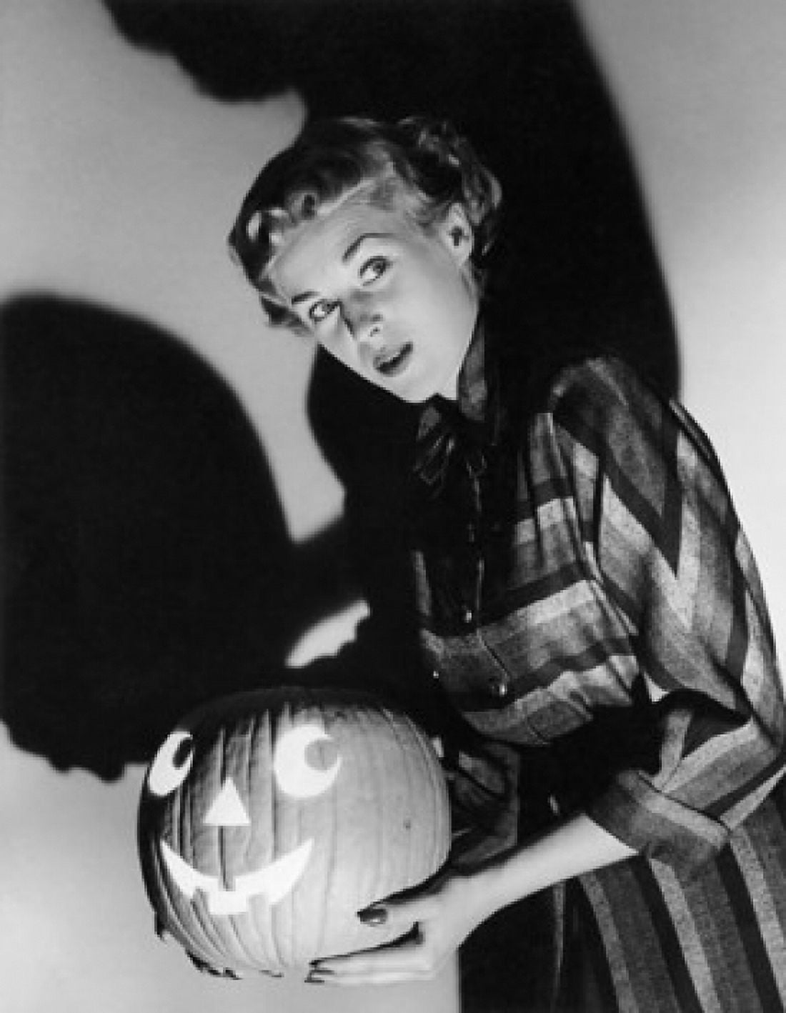 Side profile of a young woman holding an illuminated jack o lantern Canvas Art - (18 x 24)