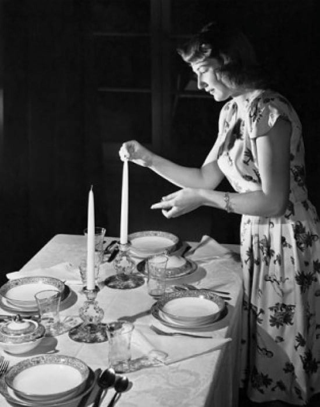 Side profile of a young woman lighting a candle at the dining table Canvas Art - (18 x 24)