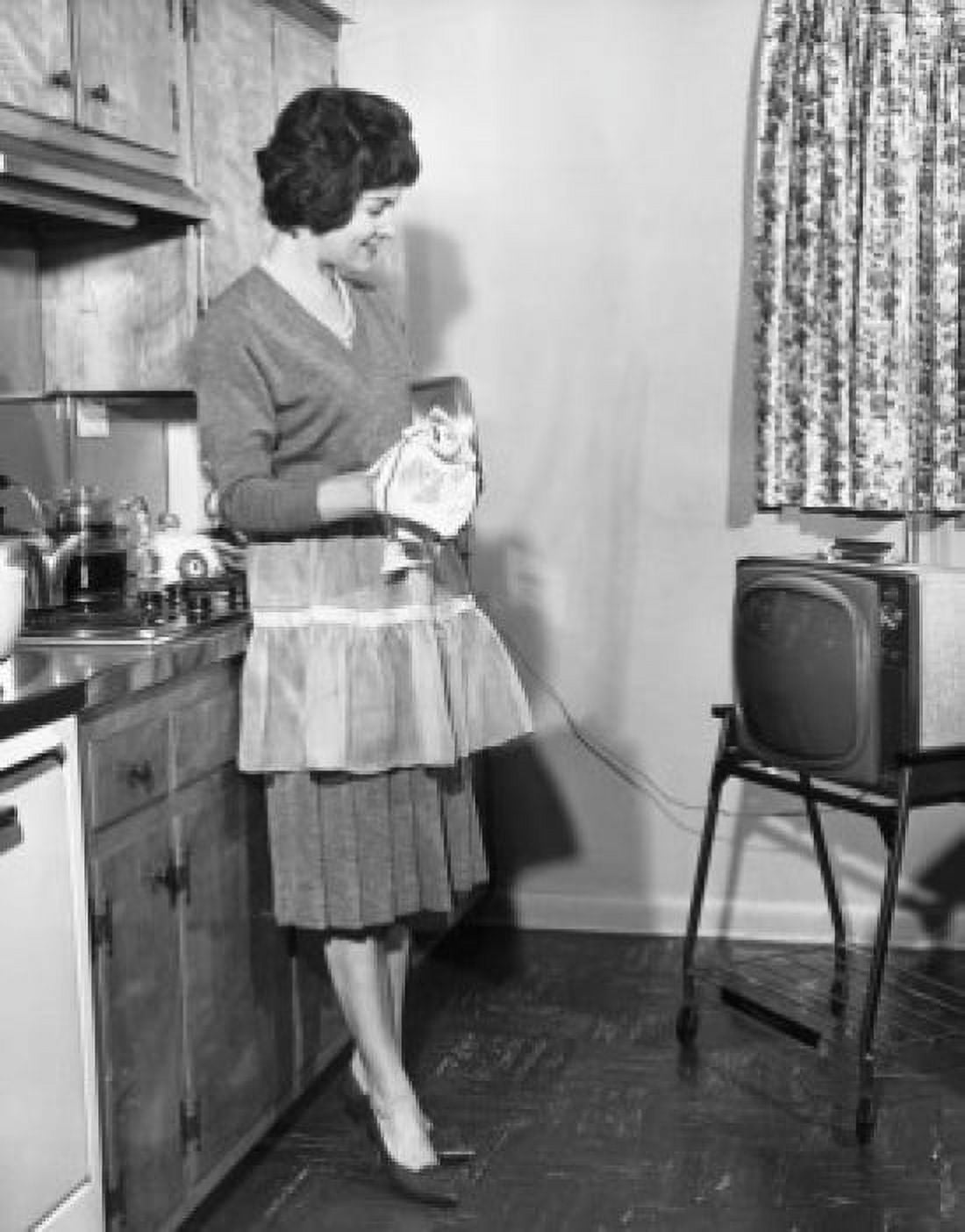 Side profile of a young woman looking at a television in the kitchen Canvas Art - (18 x 24)