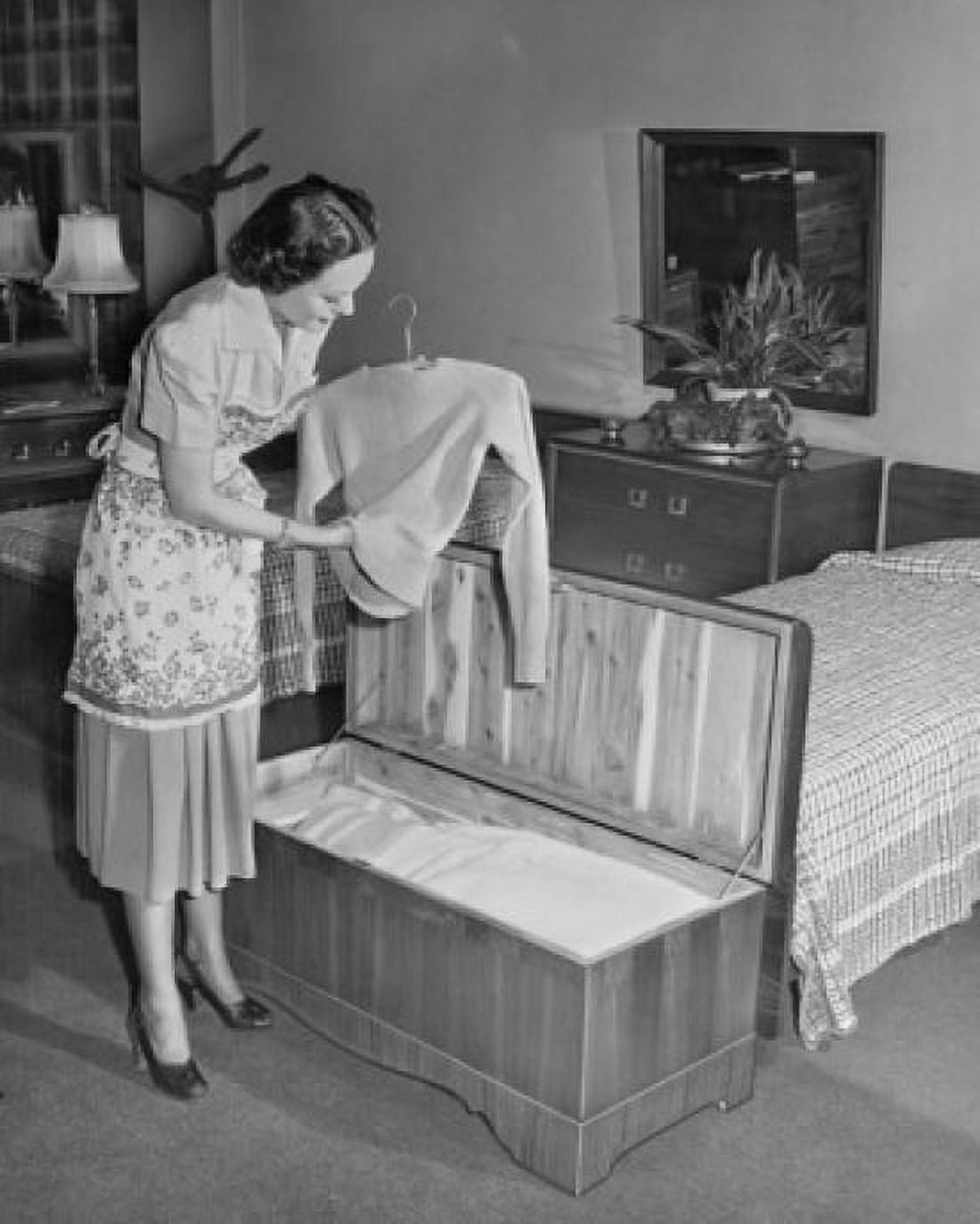 Side profile of a young woman putting clothes in a cedar chest Canvas Art - (24 x 36)