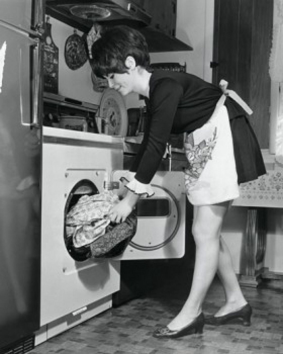 Side profile of a young woman putting clothes into a dryer Canvas Art - (24 x 36)