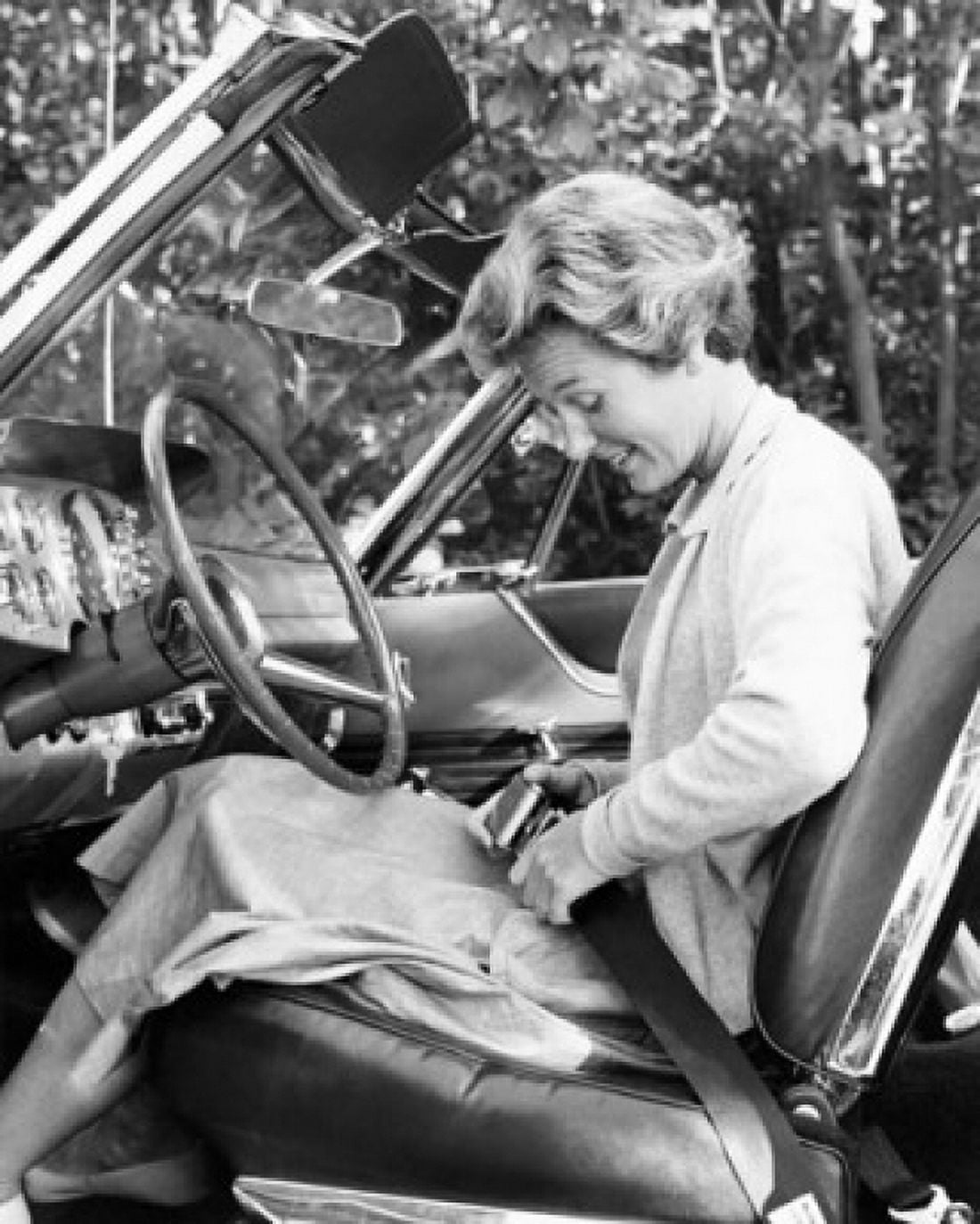 Side profile of a young woman sitting in the drivers seat and fastening the seat belt in a car Canvas Art - (18 x 24)