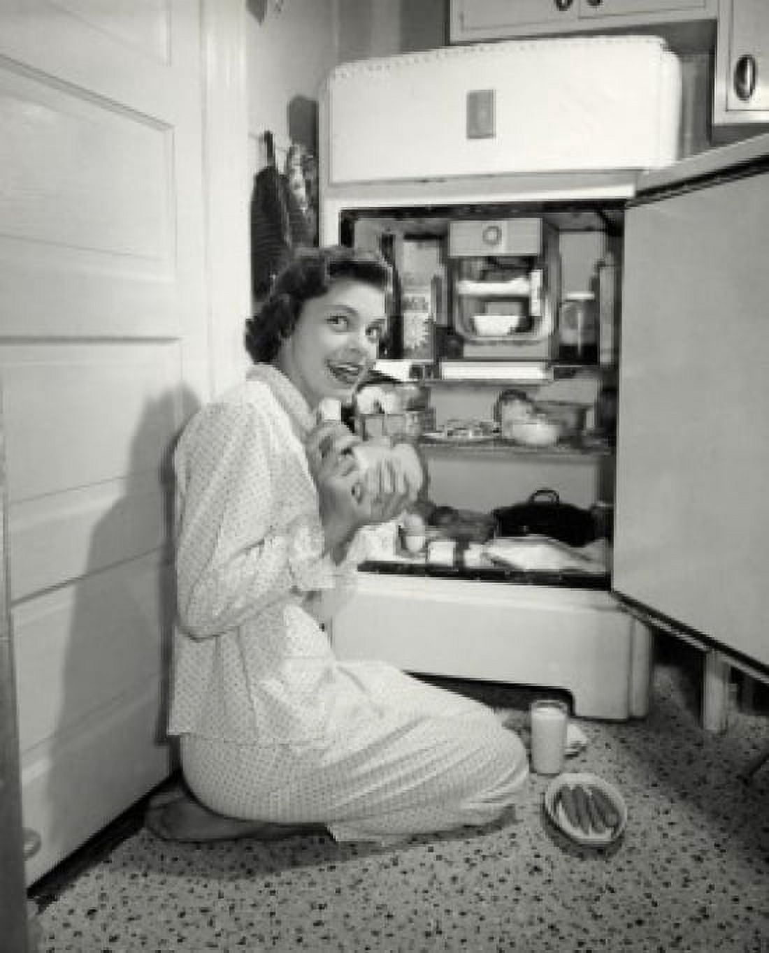 Side profile of a young woman taking out food from a refrigerator Canvas Art - (24 x 36)