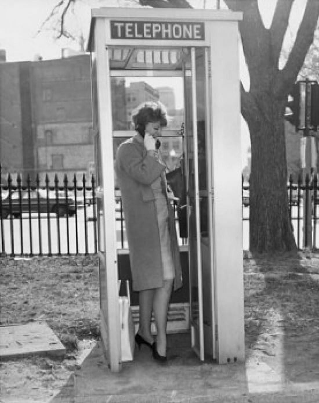 Side profile of a young woman talking on the phone in a telephone booth Canvas Art - (24 x 36)